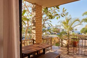 Beachside Palm Beach Luxury - 2 Bedroom Apartment في غولد كوست: فناء مع طاولة خشبية وشرفة
