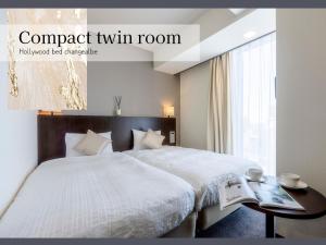 a bedroom with a bed and a table and a window at Hotel Gracery Sapporo in Sapporo
