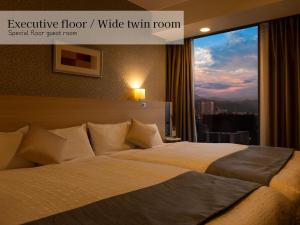 a large bed in a hotel room with a window at Hotel Gracery Sapporo in Sapporo