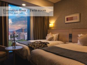 a hotel room with two beds and a window at Hotel Gracery Sapporo in Sapporo