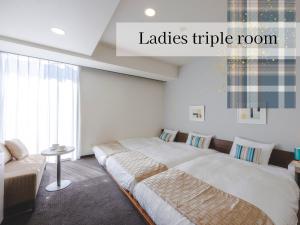 a bedroom with a large bed and a couch at Hotel Gracery Sapporo in Sapporo