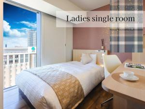 a bedroom with a bed and a large window at Hotel Gracery Sapporo in Sapporo