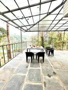 un patio avec une table et des chaises sur un patio dans l'établissement Lakeview Inn Homestay - Entire home, à Anaviratty