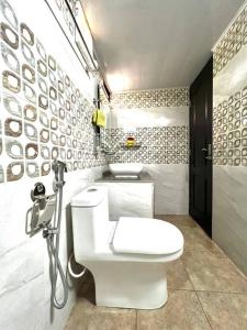 une salle de bain avec des toilettes blanches et deux lavabos dans l'établissement Lakeview Inn Homestay - Entire home, à Anaviratty