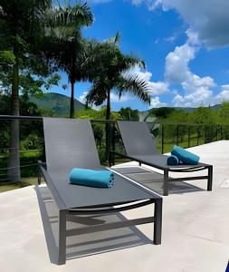 アナポイマにあるAnapoima Casa Finca Piscina, Jacuzzi, Golf y Tenisの- パティオ(青い枕とラウンジチェア2脚付)