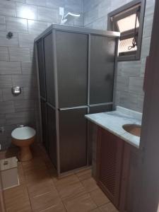 a bathroom with a toilet and a sink and a mirror at Aptos Enseada Prox Praia in São Francisco do Sul
