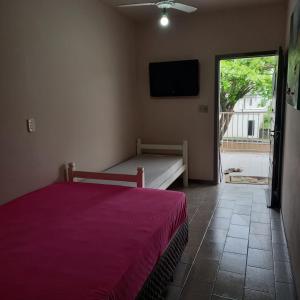 a bedroom with a bed and a flat screen tv at Aptos Enseada Prox Praia in São Francisco do Sul