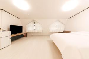 a bedroom with a bed and a flat screen tv at Seorak HOT Spring Mammoth Resotel in Sokcho
