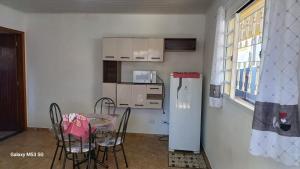 カンポス・ド・ジョルドンにあるApartamento Kit 04, em Campos do Jordãoのテーブルと冷蔵庫のある小さなキッチン