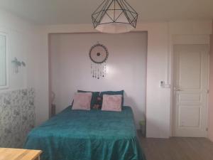 a bedroom with a bed with a green blanket at Location villa ventilée T3 DUCOS in Ducos