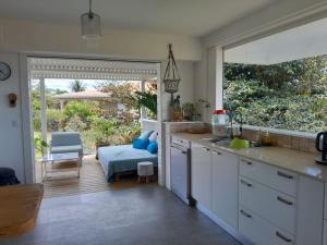 a kitchen with white cabinets and a view of a patio at Location villa ventilée T3 DUCOS in Ducos