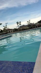 una piscina con acqua blu e palme di G Hotel a Dauis