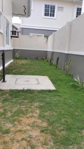 a yard of a house with a wall and grass at G Hotel in Dauis