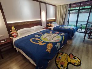 two beds in a hotel room with a monkey bedspread at Guilin Yi Characteristic Hotel CoLTD in Guilin
