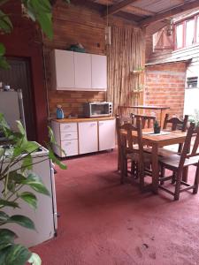 a kitchen and dining room with a table and chairs at Bungalow Hostel Iguazú in Puerto Iguazú +22 photos