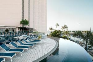 una piscina con sillas azules y un edificio en Prince Waikiki en Honolulu
