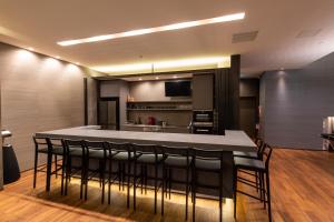 a kitchen with a bar with black chairs in it at Nero in Kutchan