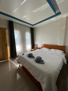 - une chambre avec un lit avec deux chapeaux dans l'établissement FOUR-G HOMESTAY & Komodo Tour, à Labuan Bajo