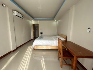 - une chambre avec un lit et un bureau dans l'établissement FOUR-G HOMESTAY & Komodo Tour, à Labuan Bajo