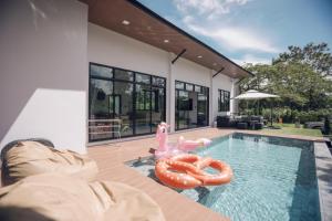 a swimming pool with a pink flamingo and an inflatableinyl at Issara Private Pool Villa Khaoyai in Pak Chong