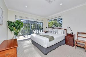 a bedroom with a bed and a large window at Wangi Dreaming in Wangi Wangi
