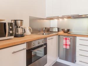 a kitchen with a sink and a stove top oven at Studio rénové avec balcon sud, skis aux pieds, parking et grand jardin, La Salle-les-Alpes - FR-1-330F-237 in La Salle Les Alpes