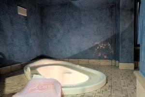Habitación con paredes azules y baño con bañera. en Bio Hotel Villa Cecilia, en Livigno