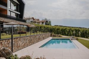 a swimming pool with a stone wall next to a house at Stollhof - NEW in Lagundo