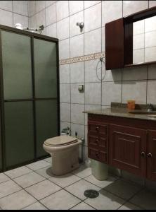 a bathroom with a toilet and a shower and a sink at Belíssima Chácara de Alto Padrão em Boituva in Boituva