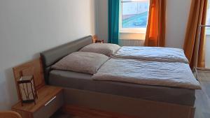 Bett in einem kleinen Zimmer mit Fenster in der Unterkunft Ferienwohnung Saalfeld - Sommerfrische Burkersdorf in Saalfeld