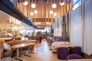 a restaurant with tables and chairs and chandeliers at Citadines Walker North Sydney in Sydney