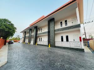 a building with a parking lot in front of it at Wiang Kham Resort in Ban Na Phra That