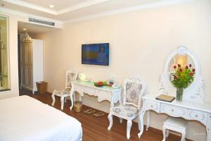 a bedroom with a bed and a table and chairs at Tuyet Son Hotel (TS Ocean Hotel) in Da Nang