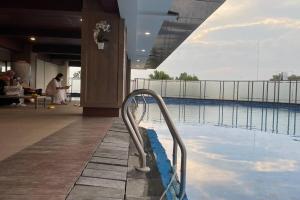 a swimming pool with a hand rail in a building at Earthy Modern 2 Bedrooms Apt in Sleman