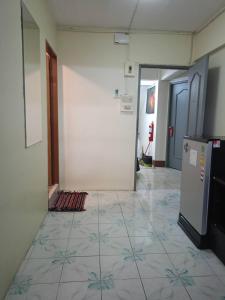 a hallway with a tile floor and a refrigerator at High5 Guesthouse in Pattaya