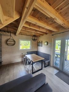 a dining room with a table and chairs at Szary Domek 4 jacuzzi kominek klimatyzacja jezioro in Trojaczek