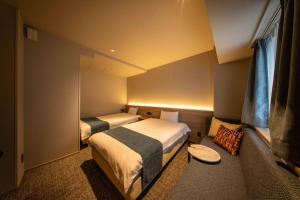 a small room with two beds and a window at New Osaka Hotel in Osaka