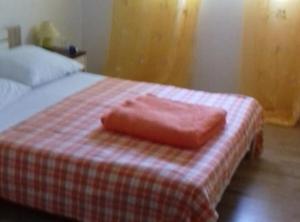 a pink towel sitting on top of a bed at Apartments Rubbi in Vrsi