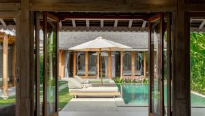 un patio al aire libre con sombrilla y piscina en Villa Du Ho by Villa Finder, en Kerobokan 20 fotos más