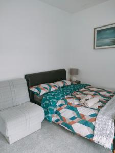 ein Schlafzimmer mit einem Bett und einem Stuhl in der Unterkunft Spacious House, Near Haigh Woodland Park, Wifi, Parking in Leigh