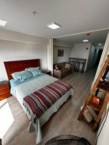 Un dormitorio con una cama grande y una sala de estar. en Minidepartamento de estreno, en Lima