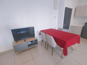 a kitchen with a table with chairs and a television at Pool View Casa Suite 5pax Midhill Genting Highlands in Genting Highlands