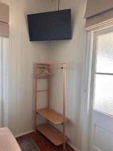Una habitación con una estantería y un televisor en la pared. en Inglewood Hotel, en Inglewood 2 fotos más