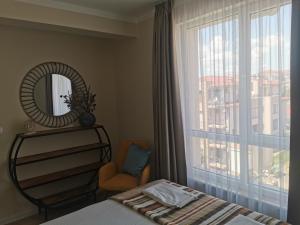 a bedroom with a bed and a mirror and a window at Amber drop with a pool in Ravda +14 photos