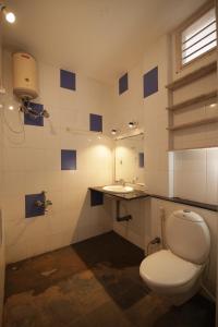a bathroom with a toilet and a sink at Holi-Wood Guesthouse in Puducherry