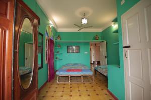 a room with two beds and green walls at Holi-Wood Guesthouse in Puducherry