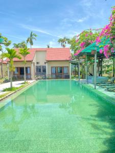 a swimming pool in front of a villa at Pastorale Villa Cam Chau in Tân Thành (1)