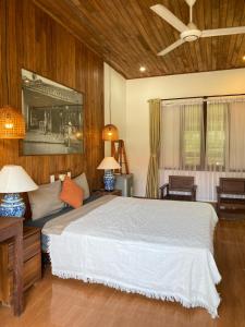 a bedroom with a large bed and two lamps at Pastorale Villa Cam Chau in Tân Thành (1) +54 photos