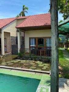 a house with a swimming pool in front of a house at Pastorale Villa Cam Chau in Tân Thành (1)