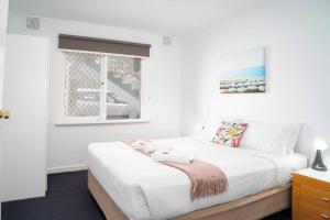 パースにあるApartment 17 Burswoodの窓のある大きな白いベッドのある寝室